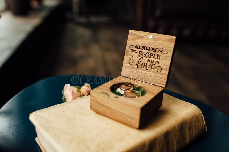 Beaux anneaux les épousant dans une boîte en bois sur un vieux livre de famille images stock Beaux anneaux les épousant dans une boîte en bois sur un vieux livre de famille images stock