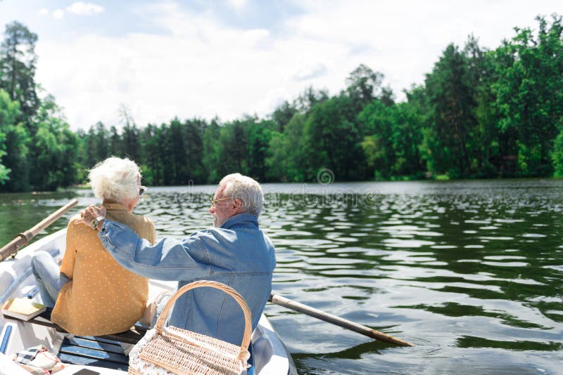 Beaux couples des retraités étreignant dans le bateau et la détente photographie stock libre de droits Beaux couples des retraités étreignant dans le bateau et la détente photographie stock libre de droits