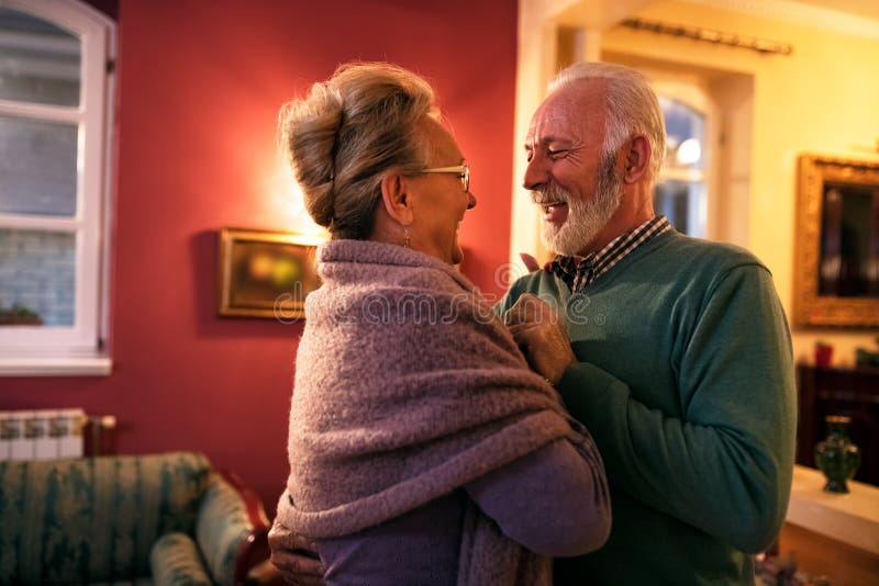 Beaux couples supérieurs de sourire dans l'amour dansant à la maison image libre de droits Beaux couples supérieurs de sourire dans l'amour dansant à la maison image libre de droits