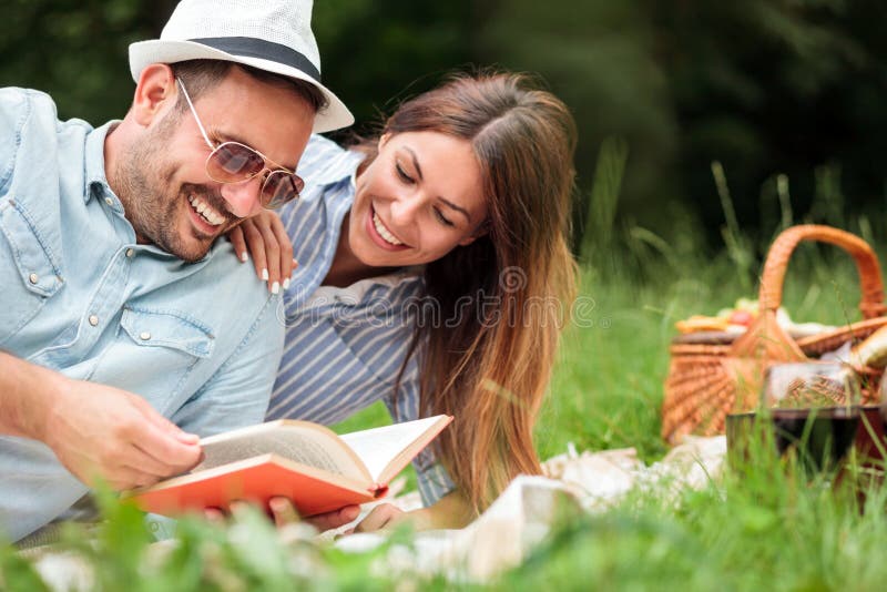Beaux jeunes couples ayant un pique-nique romantique de détente dans un parc images libres de droits Beaux jeunes couples ayant un pique-nique romantique de détente dans un parc images libres de droits