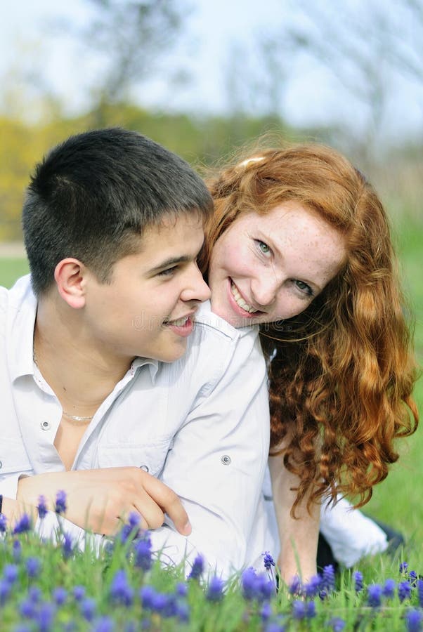Beaux jeunes couples dans l'amour sur une clairière verte photographie stock libre de droits Beaux jeunes couples dans l'amour sur une clairière verte photographie stock libre de droits