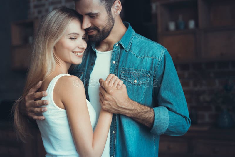 Beaux jeunes couples étreignant en leur nouvel appartement image libre de droits
