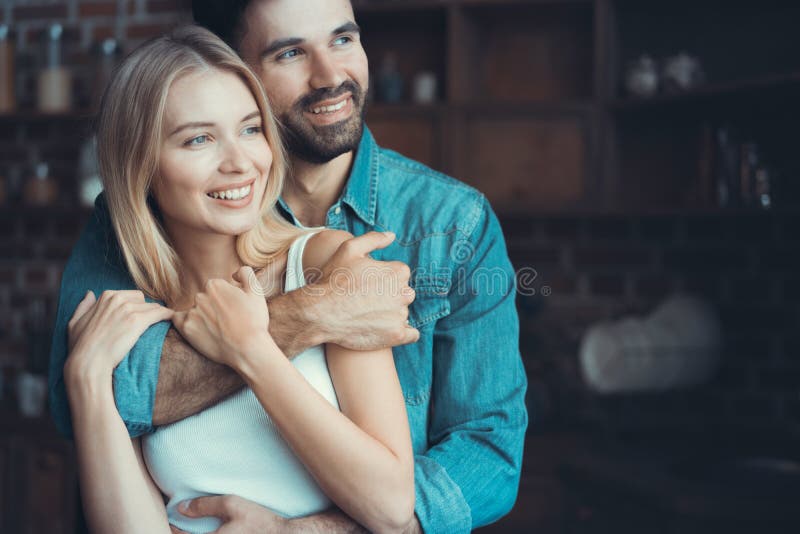 Beaux jeunes couples étreignant en leur nouvel appartement photos libres de droits