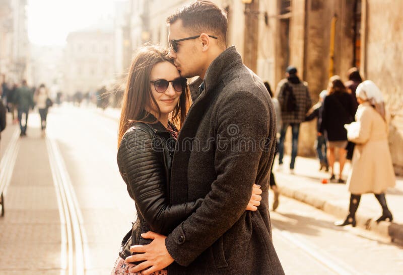 Beaux jeunes couples étreignant à la rue photographie stock Beaux jeunes couples étreignant à la rue photographie stock