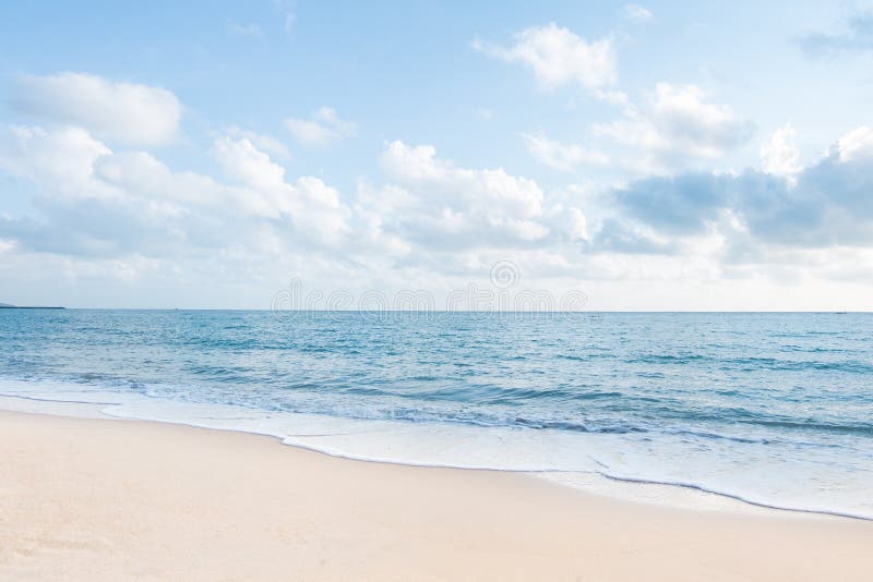 Beaux plage et ressacs blancs de sable avec le ciel bleu clair