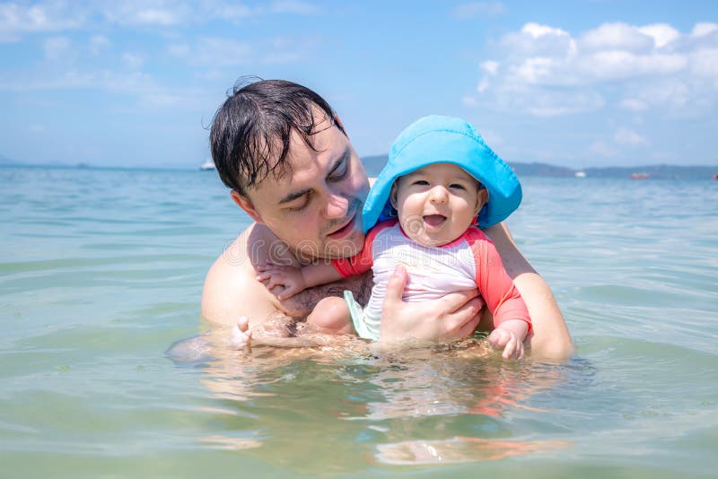 Beb? infantil de risa feliz con el pap? que se divierte en el mar El padre ense?a a la hija a nadar y a regar foto de archivo Beb? infantil de risa feliz con el pap? que se divierte en el mar El padre ense?a a la hija a nadar y a regar foto de archivo