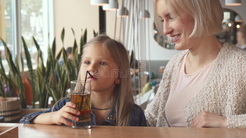 Bebida da menina alguma bebida através de uma palha no café fotografia de stock royalty free