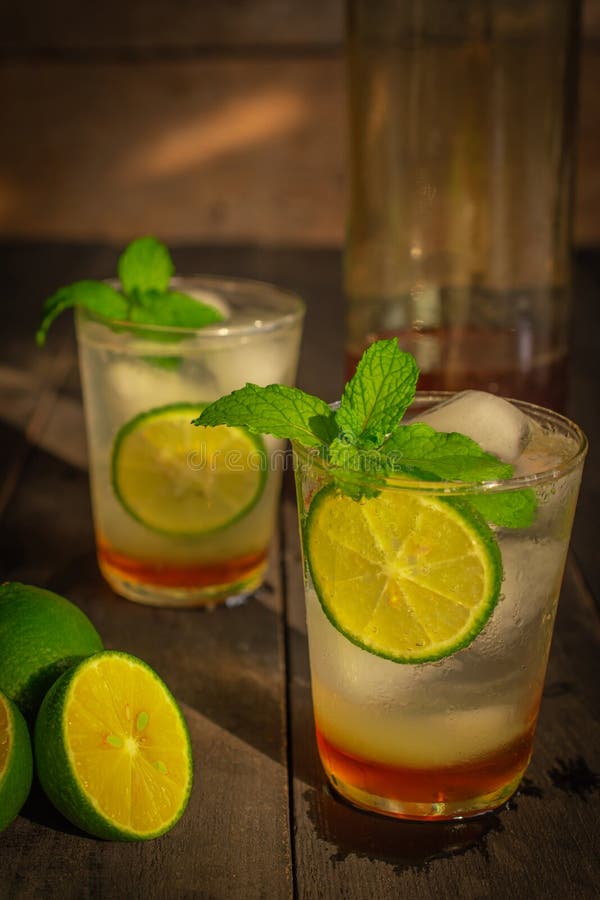A bebida fresca da soda de Honey Lemon do gelo na tabela de madeira lá é fatia do limão, o mesmo objeto e o mel na garrafa de vid imagem de stock royalty free A bebida fresca da soda de Honey Lemon do gelo na tabela de madeira lá é fatia do limão, o mesmo objeto e o mel na garrafa de vid imagem de stock royalty free