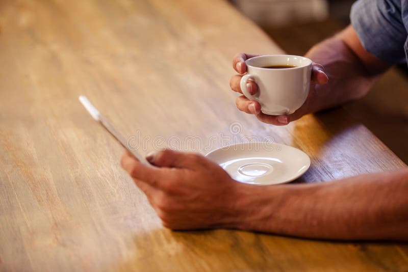 Bebouwd beeld van de hipstermens die smartphone gebruiken terwijl het drinken van kop van koffie royalty-vrije stock afbeelding Bebouwd beeld van de hipstermens die smartphone gebruiken terwijl het drinken van kop van koffie royalty-vrije stock afbeelding