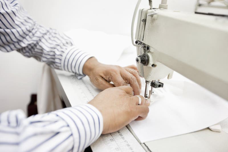 Bebouwd beeld van kleermakers naaiende doek op naaimachine