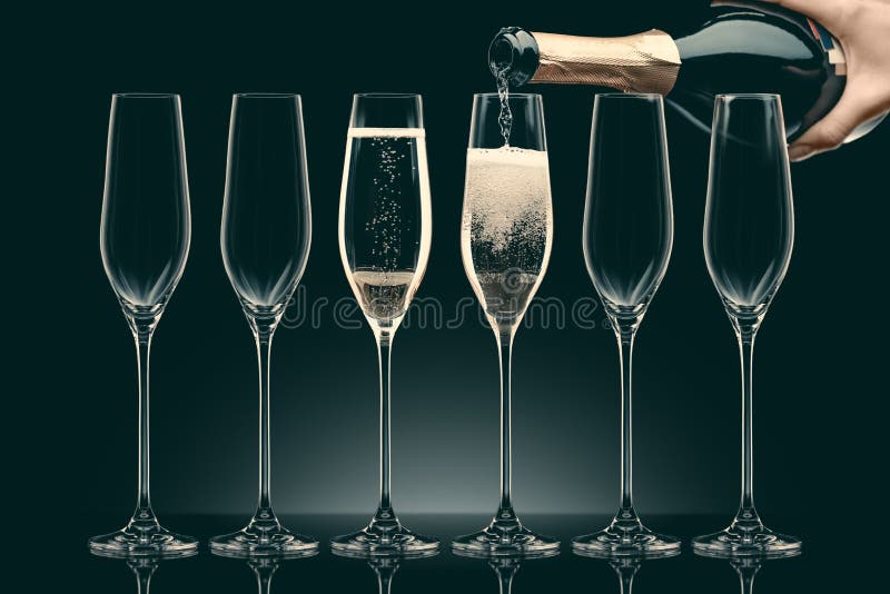 Bebouwd beeld van vrouwen gietende champagne van fles in zes transparante glazen stock fotografie Bebouwd beeld van vrouwen gietende champagne van fles in zes transparante glazen stock fotografie