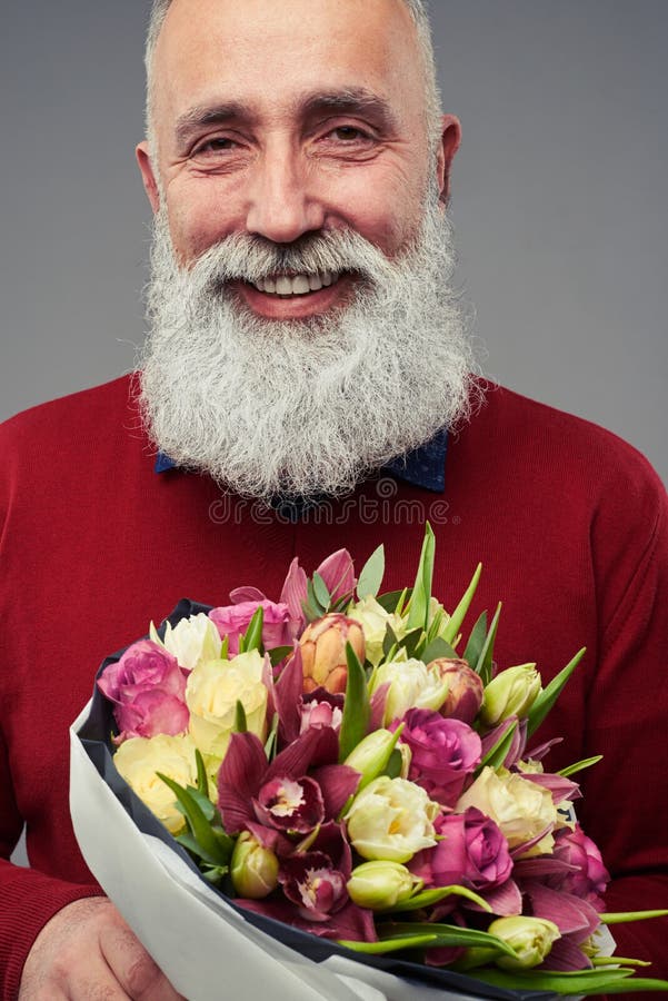 Bebouwd schot van de gebaarde mens met een boeket van tulpen royalty-vrije stock fotografie Bebouwd schot van de gebaarde mens met een boeket van tulpen royalty-vrije stock fotografie