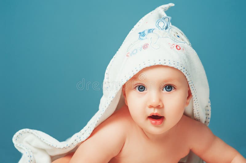 Bebé adorável Criança recém-nascida que relaxa e que coloca na barriga na cama com a toalha branca na cabeça Berçário para jovens foto de stock Bebé adorável Criança recém-nascida que relaxa e que coloca na barriga na cama com a toalha branca na cabeça Berçário para jovens foto de stock