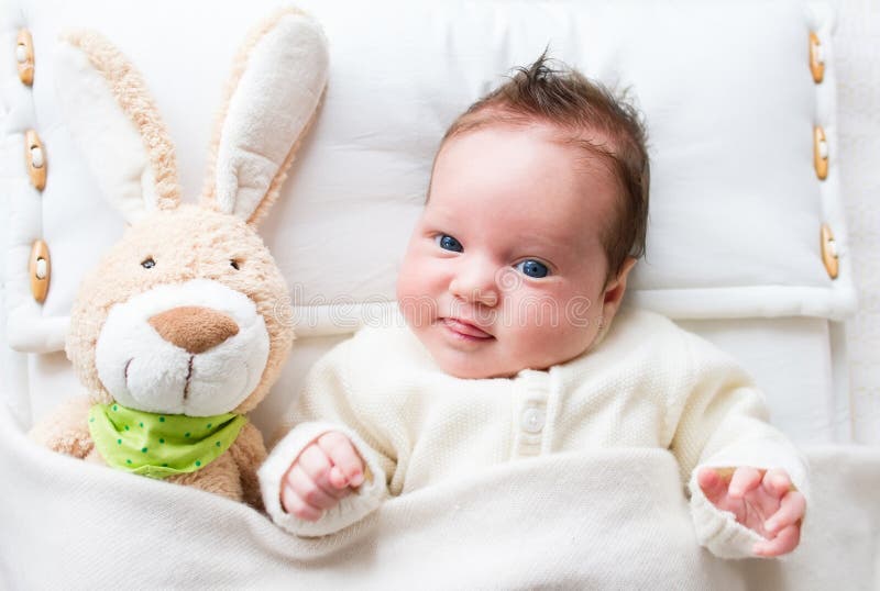 Sweet little baby girl with a toy bunny in bed. Sweet little baby girl with a toy bunny in bed