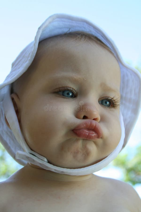 Baby girl with big cheeks and a white hat. Baby girl with big cheeks and a white hat