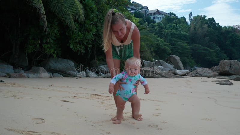 Bebé dando primeros pasos en la playa