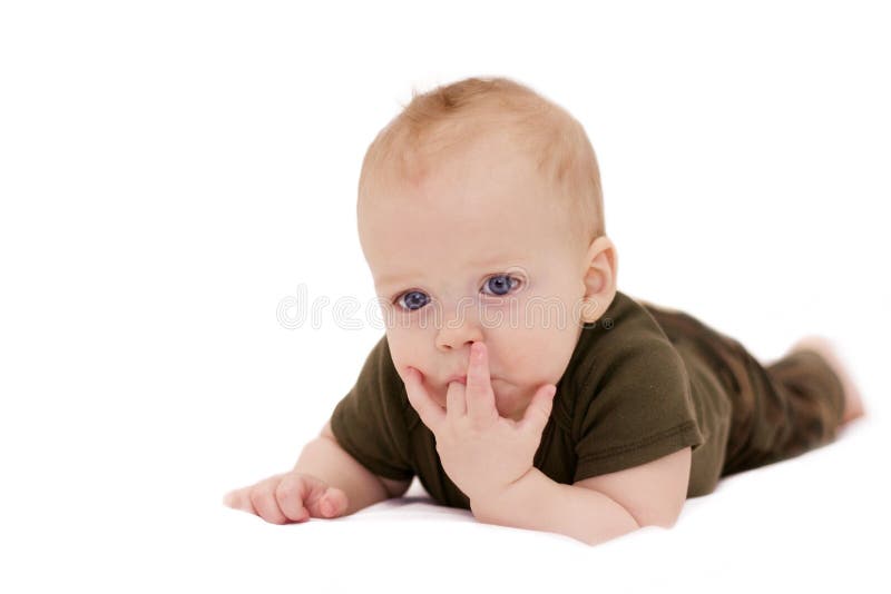 Bebé de ojos azules pensativo con un finger en la boca que se arrastra en la manta blanca contra el fondo blanco aislado que mira imagen de archivo Bebé de ojos azules pensativo con un finger en la boca que se arrastra en la manta blanca contra el fondo blanco aislado que mira imagen de archivo