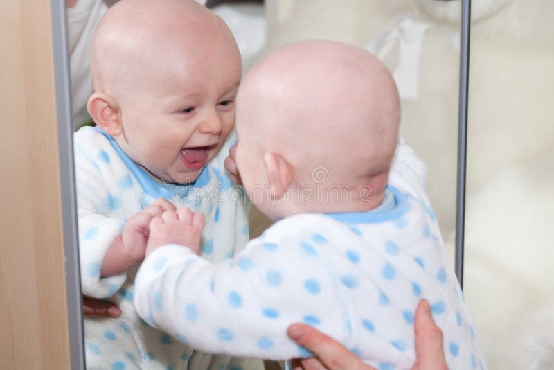 Bebé de risa que mira en espejo