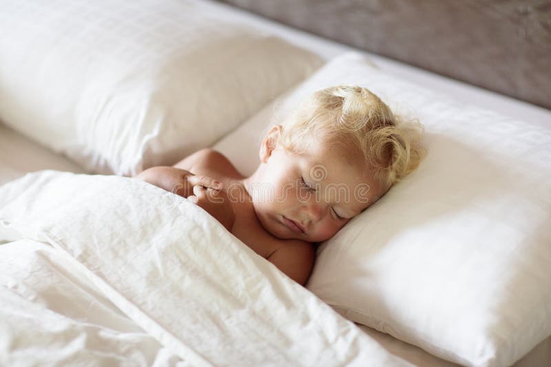 Bebé durmiendo en cama blanca fotografía de archivo libre de regalías