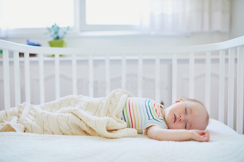 Bebé durmiendo en una cuna de dormir en la cama de los padres