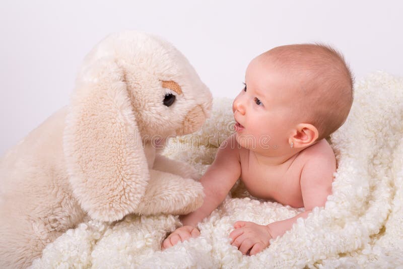 Bebé hermoso de la muchacha que juega con el conejito de pascua fotos de archivo Bebé hermoso de la muchacha que juega con el conejito de pascua fotos de archivo