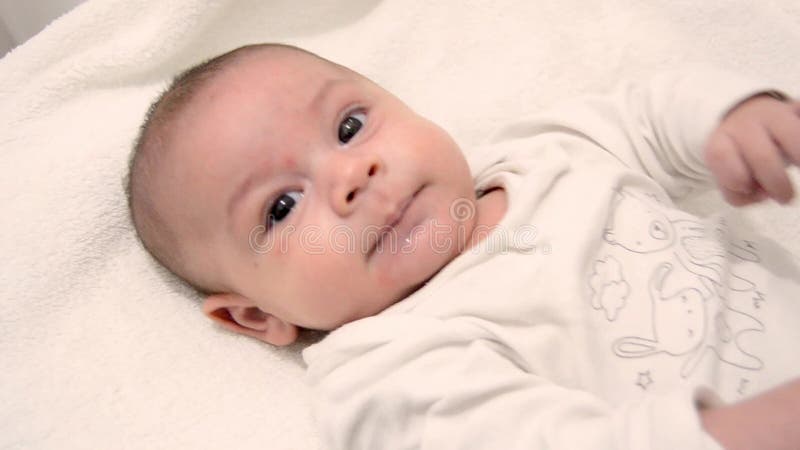Bebé lindo de los meses del tre vestido en el traje blanco del cuerpo