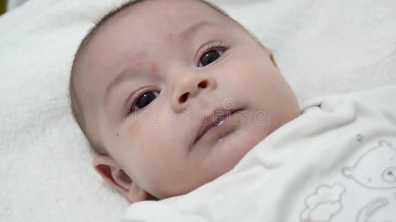 Bebé lindo de los meses del árbol vestido en el traje blanco del cuerpo