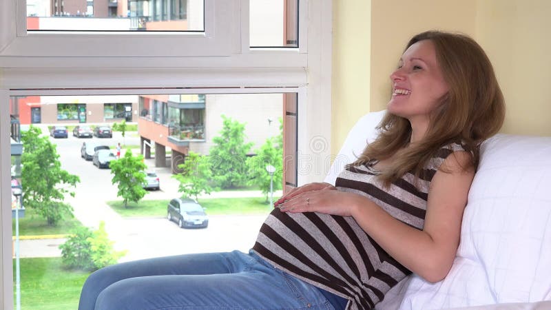 Bebé nonato de la mujer de la caricia cariñosa feliz de la oferta dentro de su panza del estómago