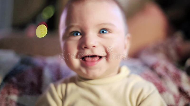 Bebé poco feliz Sonrisa, mirando para arriba alegre Ojos azules divertido Mirada a través de la cámara