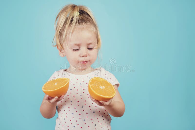 Bebé que come una naranja foto de archivo libre de regalías Bebé que come una naranja foto de archivo libre de regalías