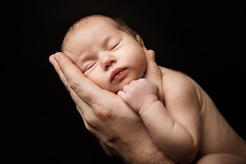Bebé recién nacido que duerme en el padre Hand, retrato recién nacido del estudio del niño