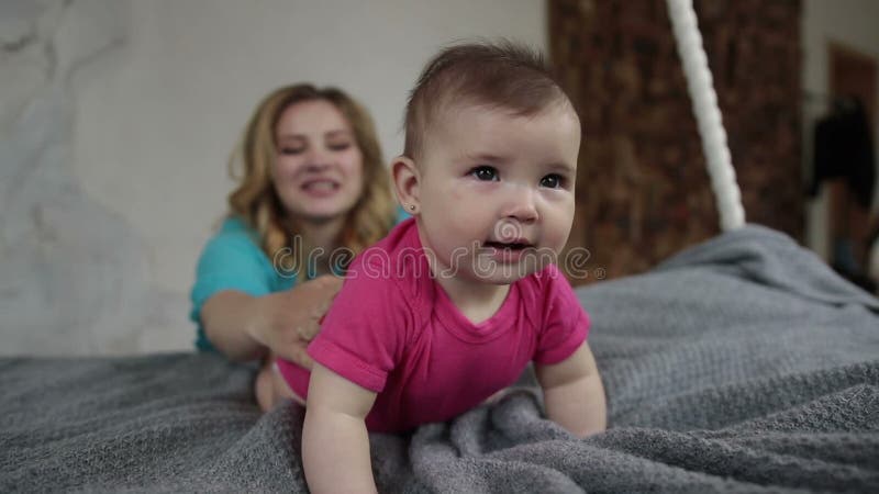 Bebê adorável que aprende rastejar na cama