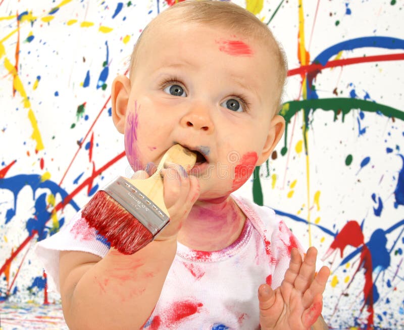 Beautiful baby covered in bright paint with paint brush. Beautiful baby covered in bright paint with paint brush