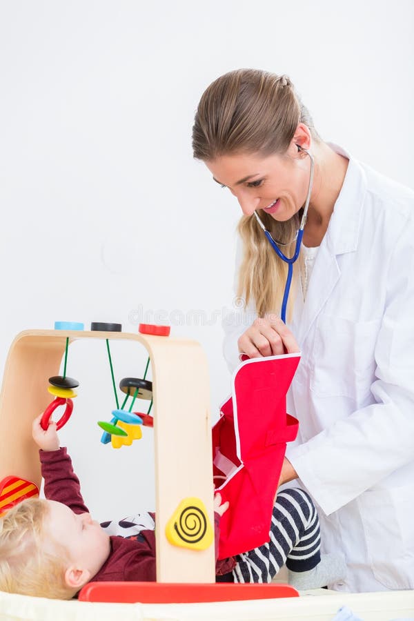Bebê bonito e saudável que joga com o estetoscópio durante r imagens de stock Bebê bonito e saudável que joga com o estetoscópio durante r imagens de stock