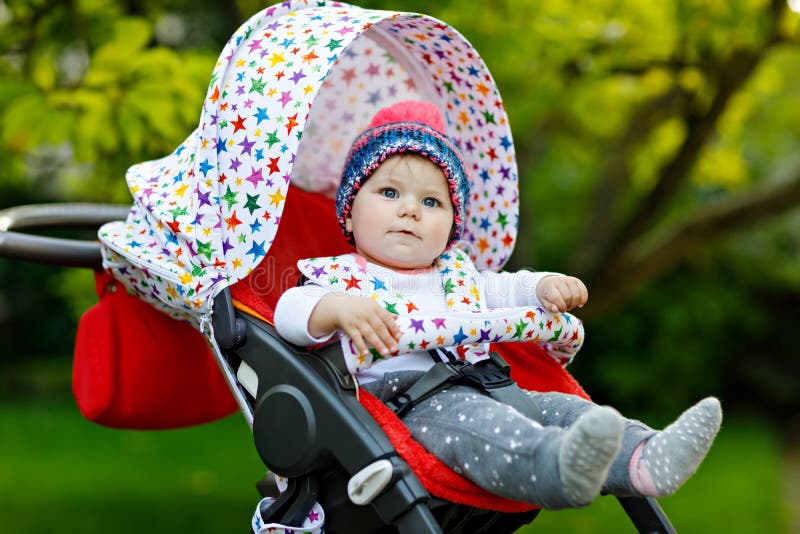 Bebê bonito pequeno bonito que senta-se na mamã do pram ou do carrinho de criança e da espera Criança de sorriso feliz com olhos fotografia de stock royalty free Bebê bonito pequeno bonito que senta-se na mamã do pram ou do carrinho de criança e da espera Criança de sorriso feliz com olhos fotografia de stock royalty free