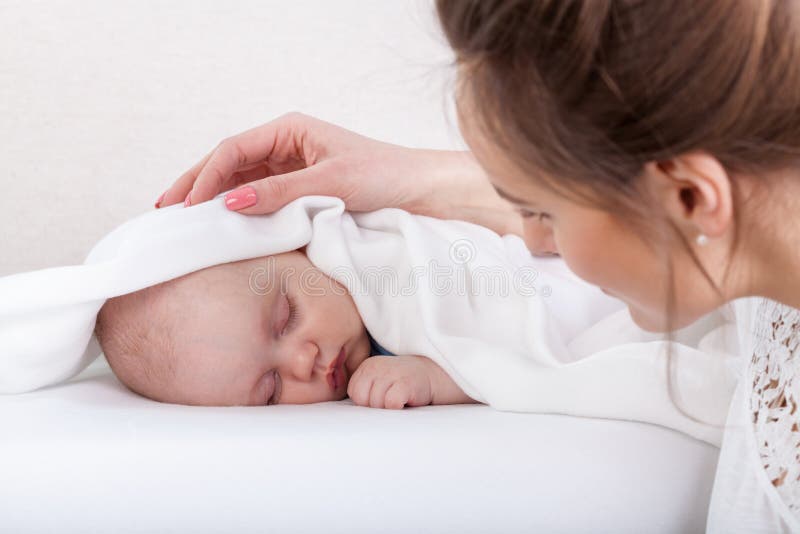 Bebê de sono e mãe de inquietação imagem de stock royalty free Bebê de sono e mãe de inquietação imagem de stock royalty free