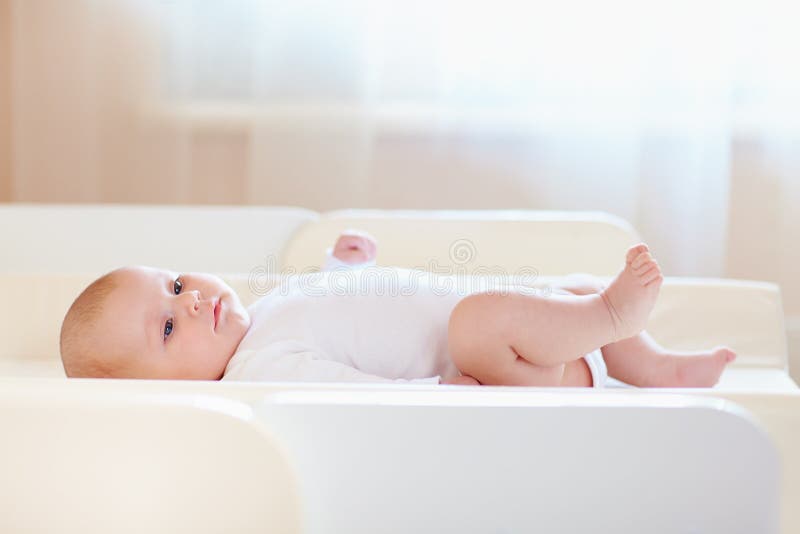 Bebê infantil bonito na tabela em mudança imagens de stock Bebê infantil bonito na tabela em mudança imagens de stock