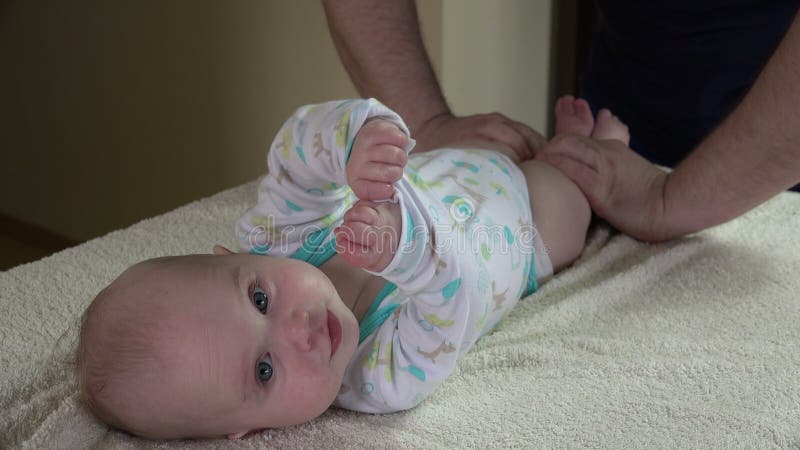 Bebê infantil do exercício do fisioterapeuta do massagista no trabalho 4K