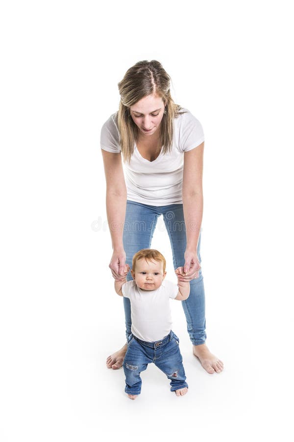 Bebê que aprende andar com a ajuda de sua mãe imagem de stock Bebê que aprende andar com a ajuda de sua mãe imagem de stock