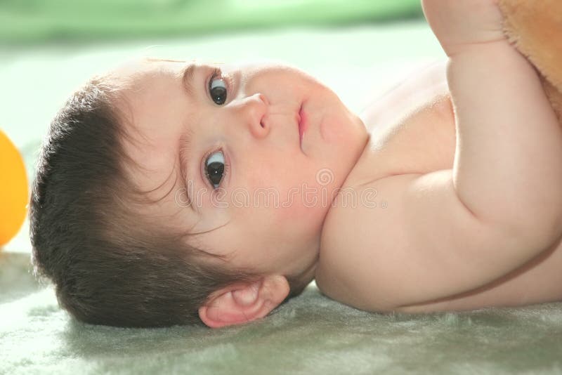 Bebê que coloc no assoalho foto de stock royalty free Bebê que coloc no assoalho foto de stock royalty free