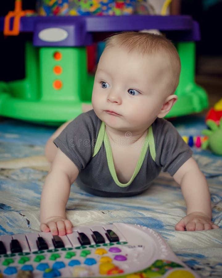 Bebê que joga com brinquedo do piano foto de stock Bebê que joga com brinquedo do piano foto de stock