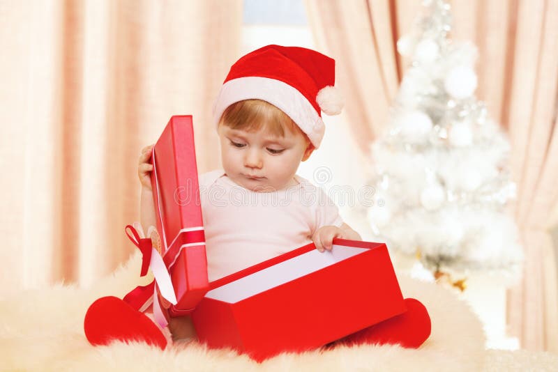 Bebê Santa com a caixa de presente vermelha grande imagens de stock Bebê Santa com a caixa de presente vermelha grande imagens de stock