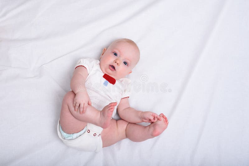 Bebê surpreso deitado no cobertor branco. recém-nascido em fraldas. conforto infantil