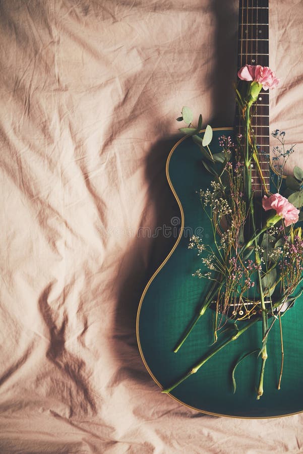 Bed, instrument and guitar with flowers in home, green and creative with nature in bedroom and above. Art, music and royalty free stock images