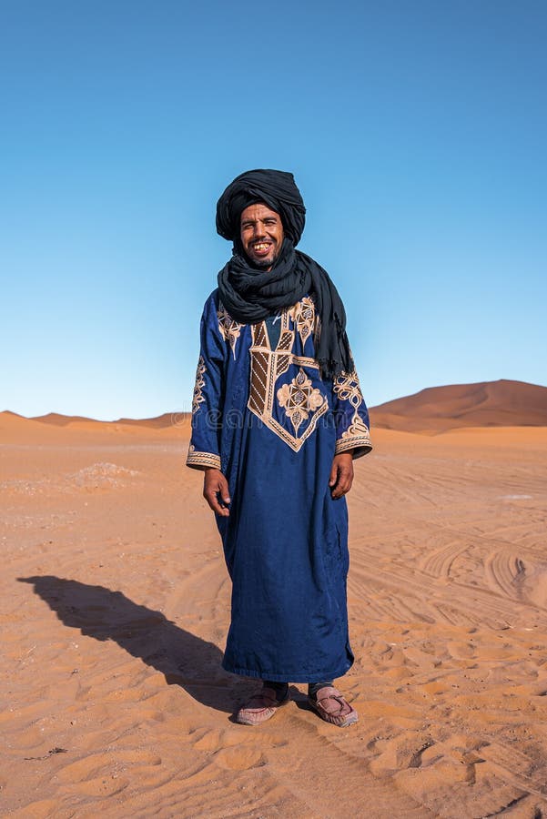 Bedouin Man Wears Traditional Clothes while Standing in Desert