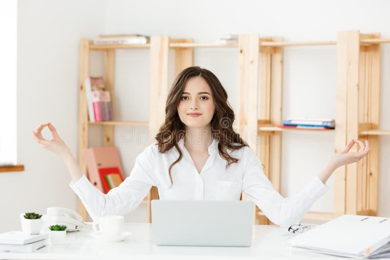 Bedrijfs en Gezondheidsconcept: Portret jonge vrouw dichtbij laptop, het praktizeren meditatie bij het bureau, voor stock afbeeldingen Bedrijfs en Gezondheidsconcept: Portret jonge vrouw dichtbij laptop, het praktizeren meditatie bij het bureau, voor stock afbeeldingen