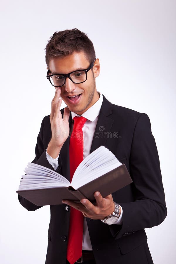 Bedrijfs mens die door het boek wordt opgewekt royalty-vrije stock foto Bedrijfs mens die door het boek wordt opgewekt royalty-vrije stock foto