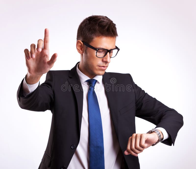 Bedrijfs mens die tijd controleert en knoop duwt stock foto Bedrijfs mens die tijd controleert en knoop duwt stock foto