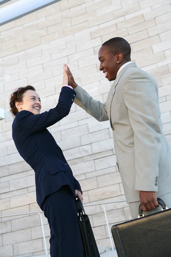 Two attractive business people celebrating a success. Two attractive business people celebrating a success