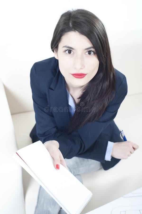 Beautiful business woman taking notes and looking to the camera. Beautiful business woman taking notes and looking to the camera